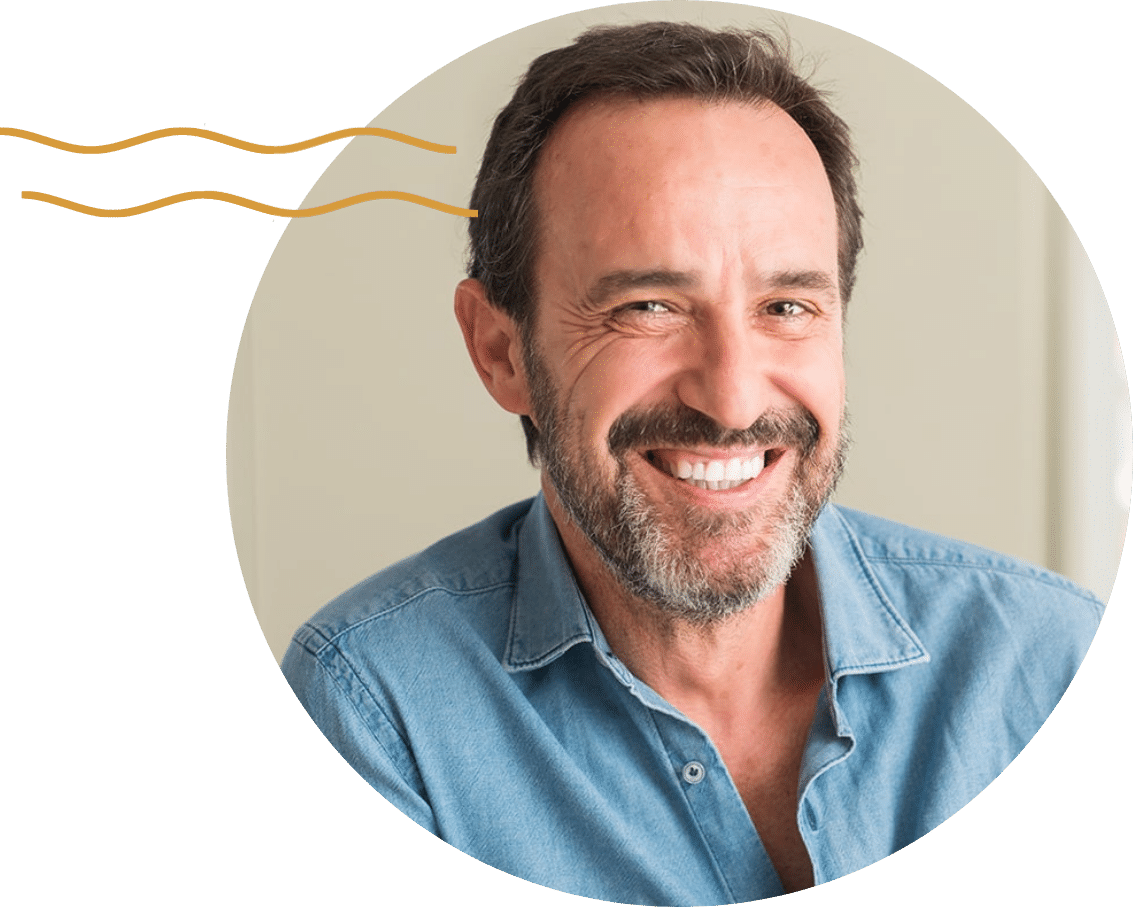 A middle-aged man in a blue button-up shirt smiling with teeth